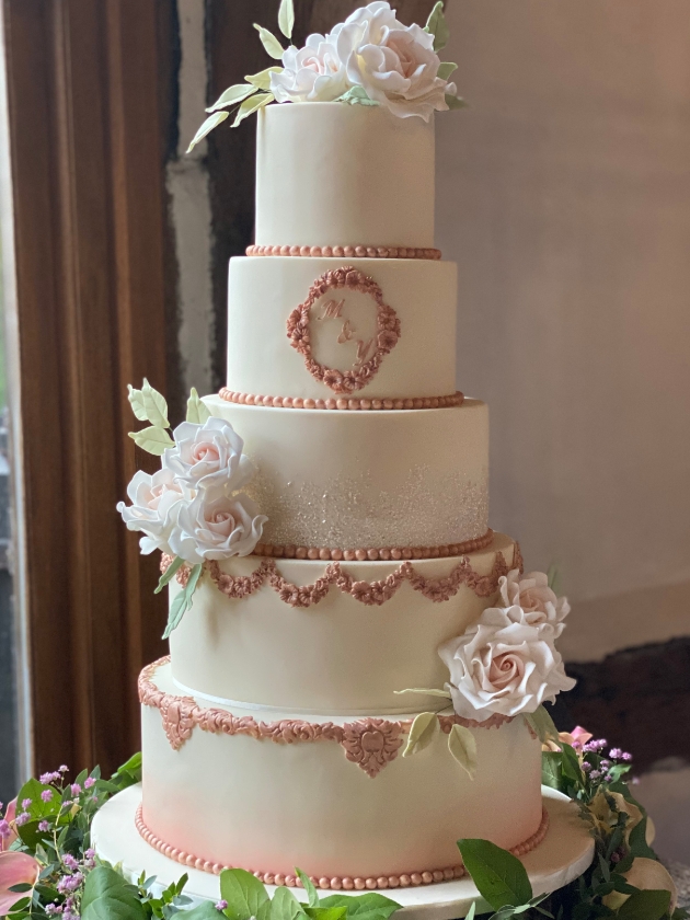 A five-tier wedding cake decorated with white flowers