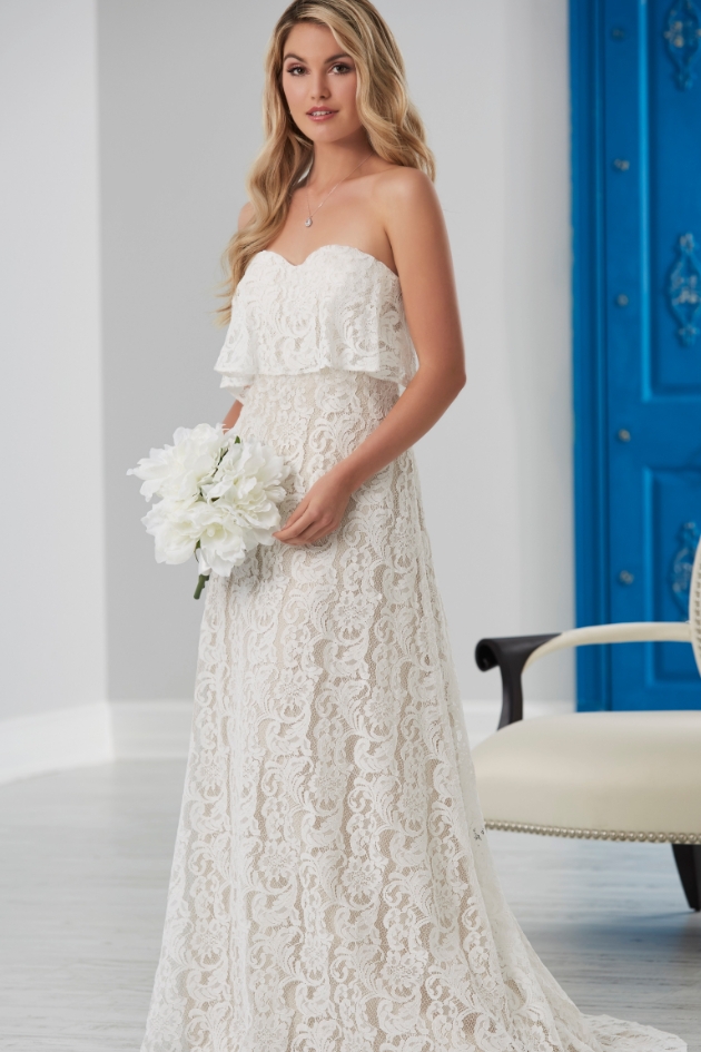 A Bohemian bride in a free-flowing wedding gown holding flowers