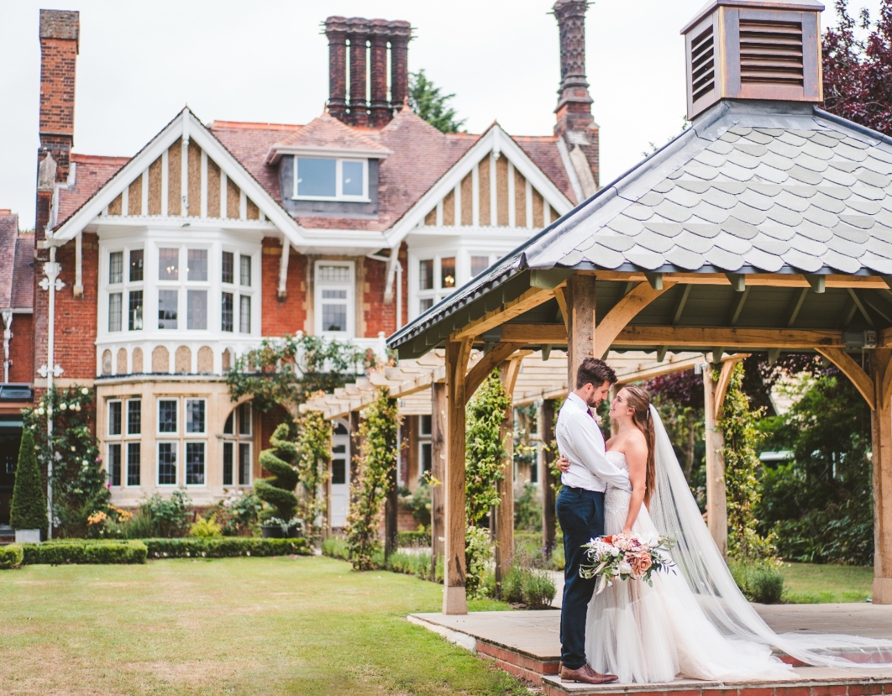 Wedded couple embrace outside Baddow Park House