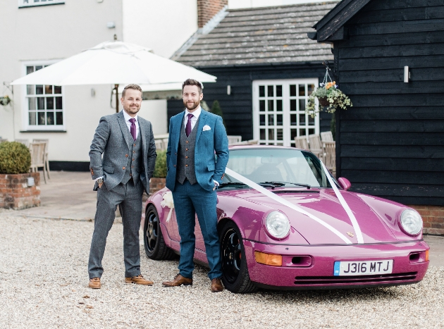 Groomsmen in bespoke suits stand in front of a purple Porsche 911
