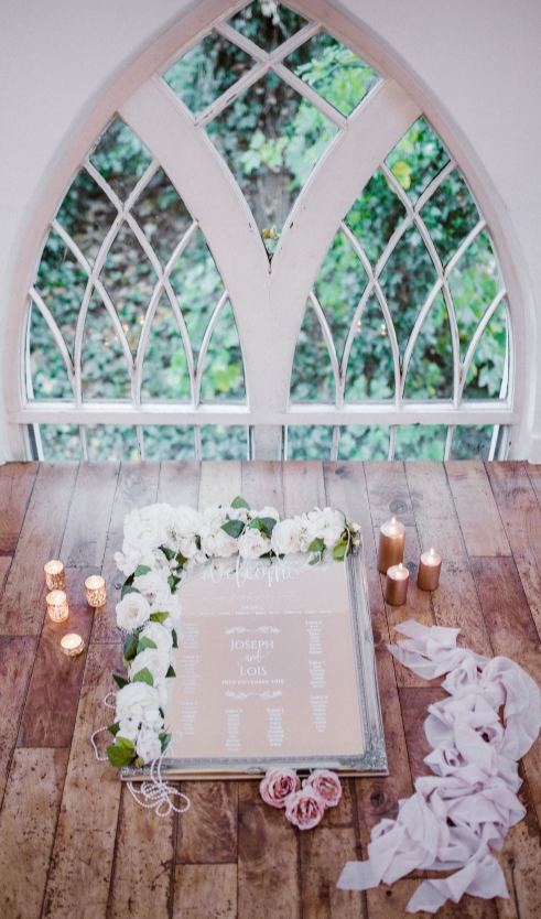 personalised mirror table plan in front of a window by Essex venue stylist Elf Occasions