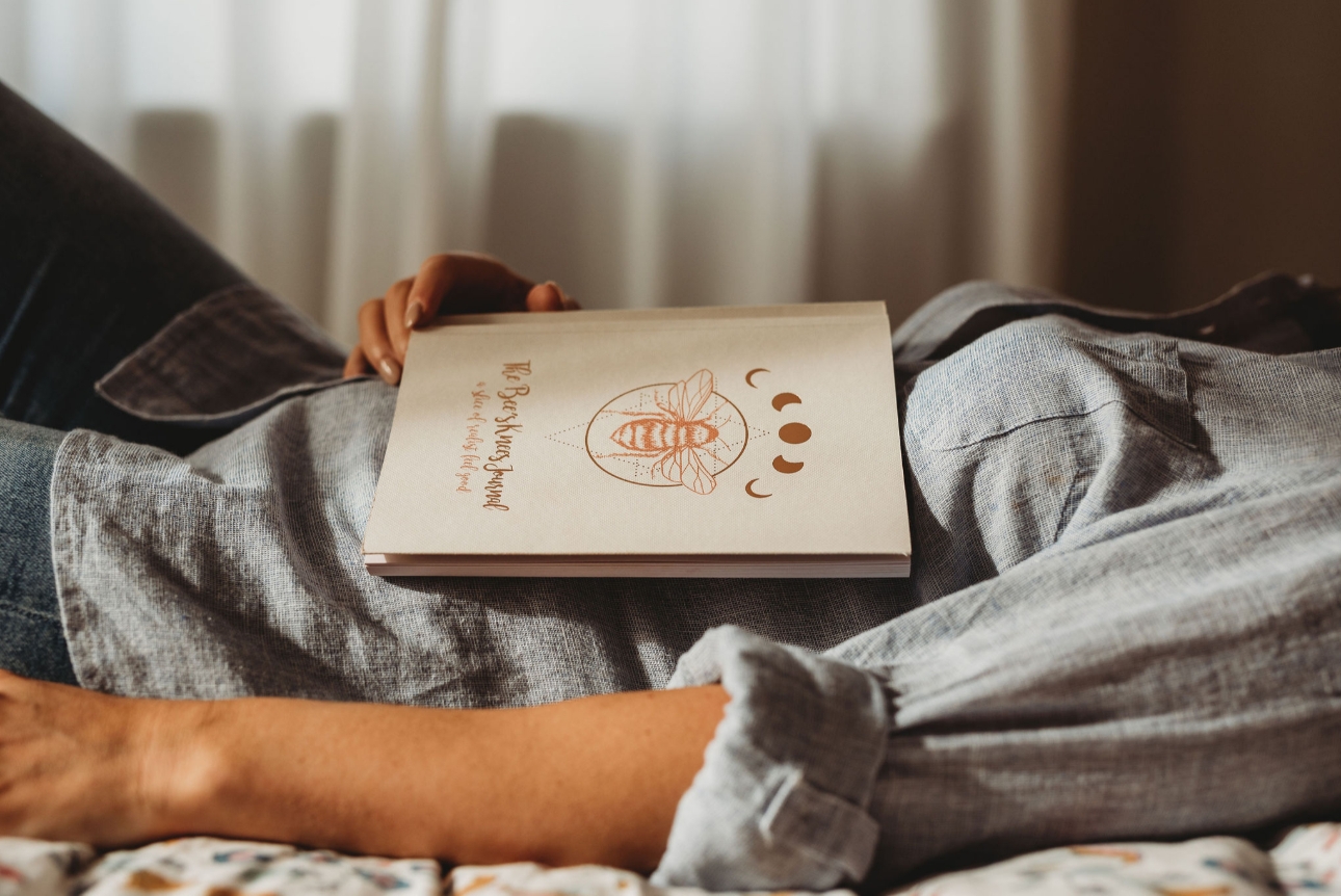 Woman lying on a bed with journal on her tummy