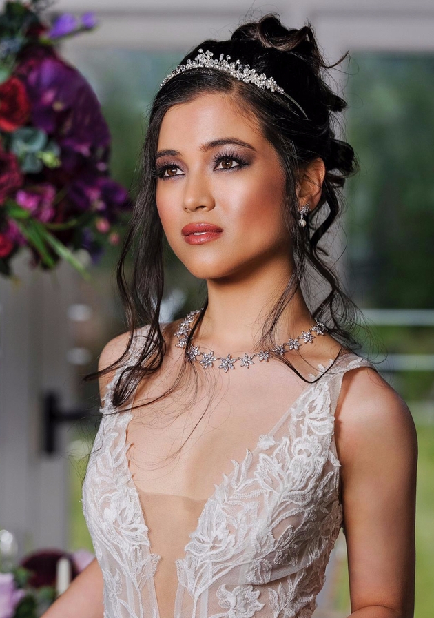 Portrait of a ride with black hair, flawless make up, lace dress and a tiara.