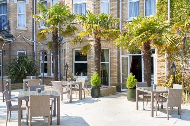 our side of hotel with chairs and palm trees