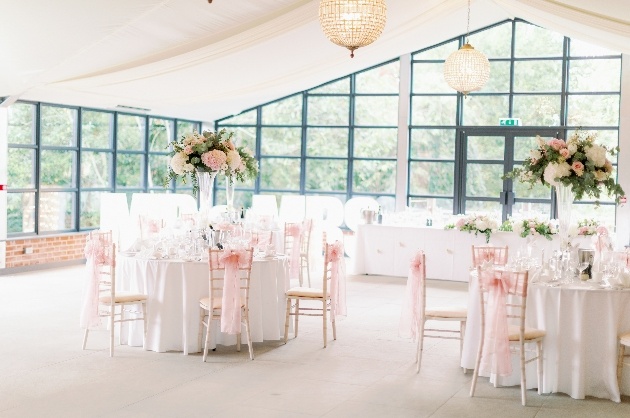 Wedding tables dressed in pink decor for wedding breakfast in the orangery at Baddow Park House in Chelmsford.