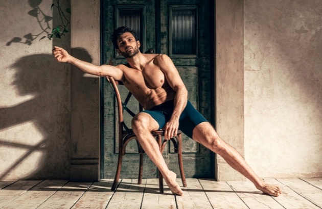 male model in boxers sitting on a chair