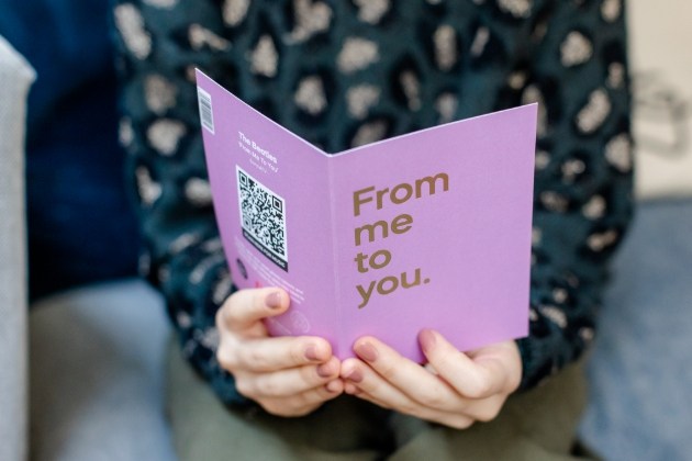 Woman holding purple from me to you card 