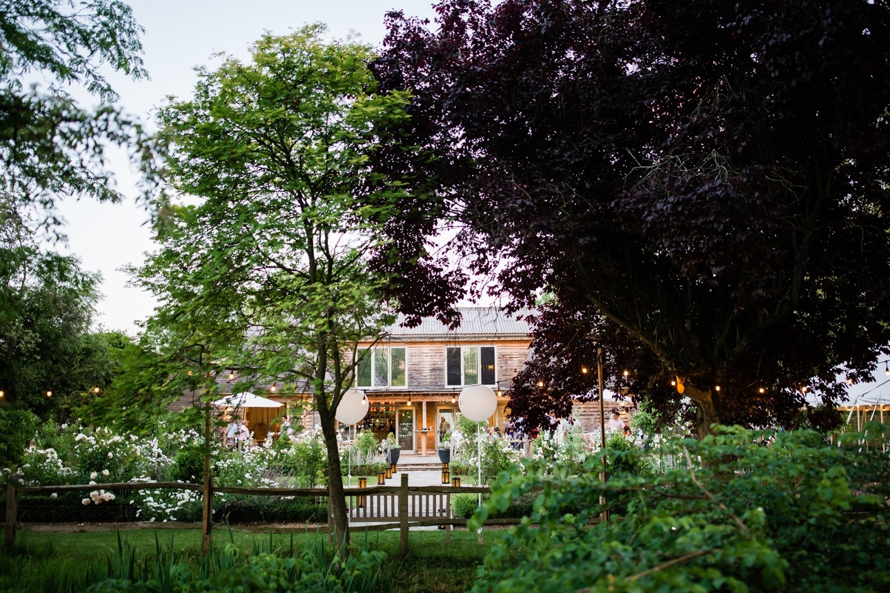 Exterior of Houchins venue in Essex with trees and festoon lighting