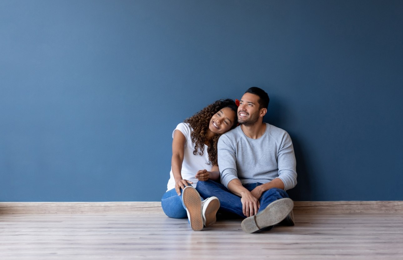 couple sitting on floor together in own home