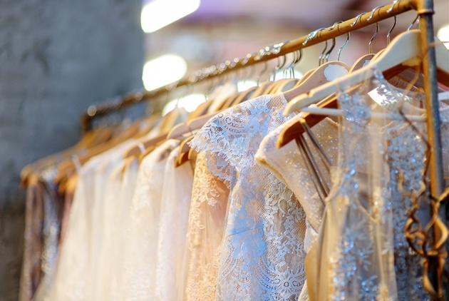 Wedding dresses hanging on a rail in a bridal boutique.