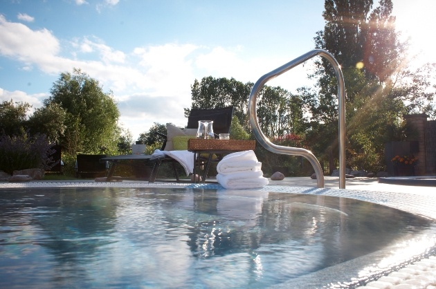 hot tub with lounger and towels on side