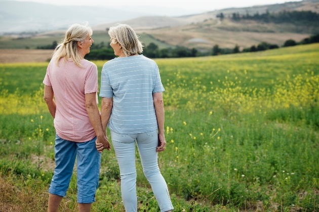 older female couple holding hands in fields