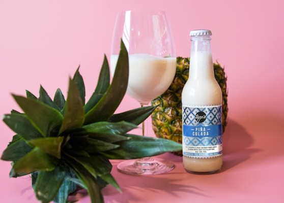 pina colada in a bottle next to a pineapple