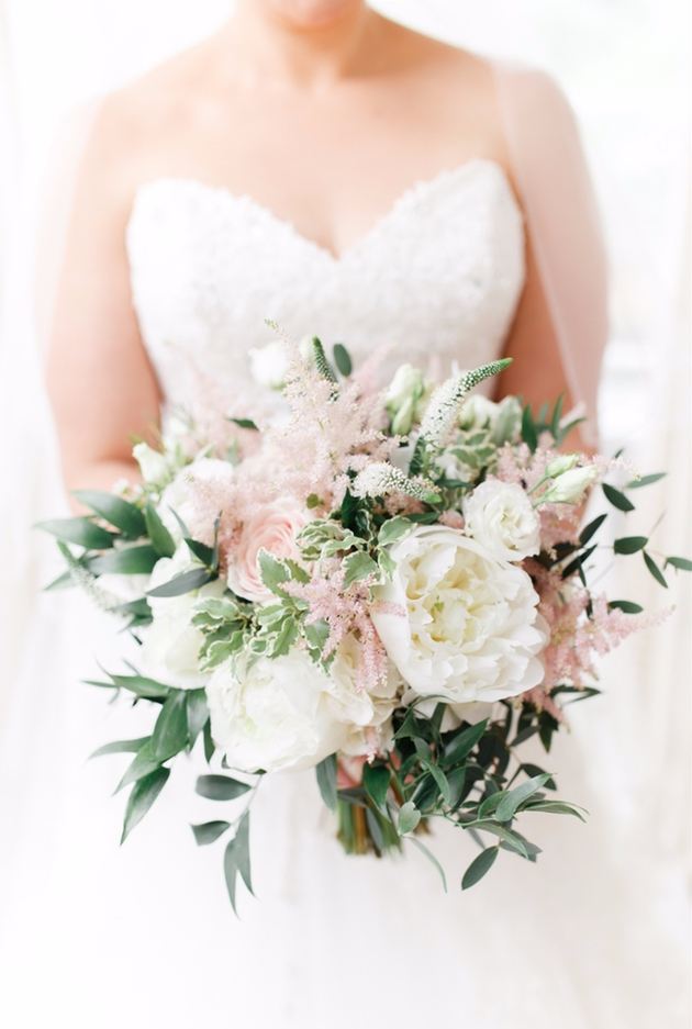 Bride holding a spring bouquet with pink and white flowers
