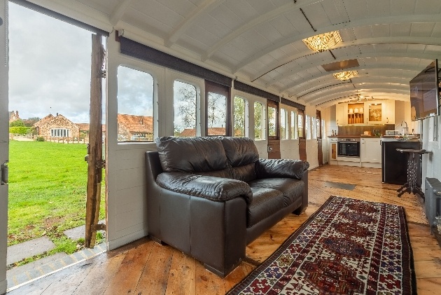 lounge area inside train leather sofa with open plan kitchen