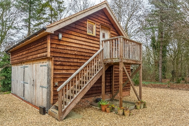 wooden lodge above garage surrounded by woods