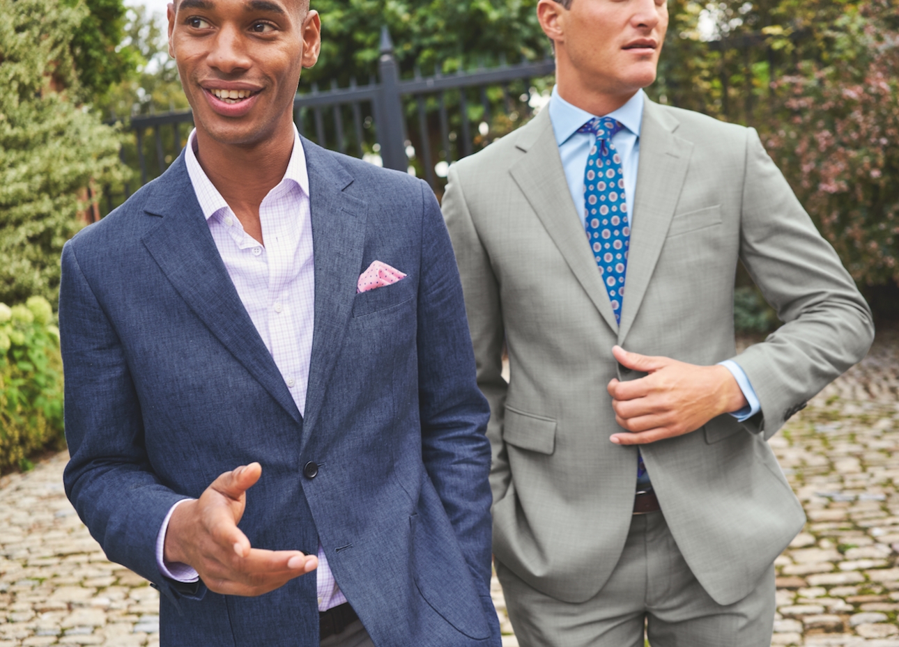 two male models in suites one grey with tie and one blue no tie