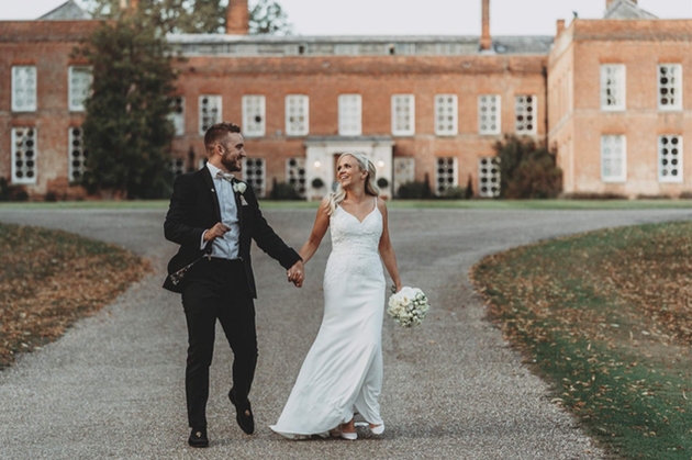 Exterior shot of Essex venue Braxted Park with newlywed couple.