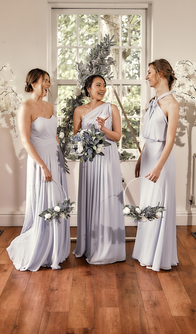 three bridesmaids wearing different styles of dress all in dusky blue