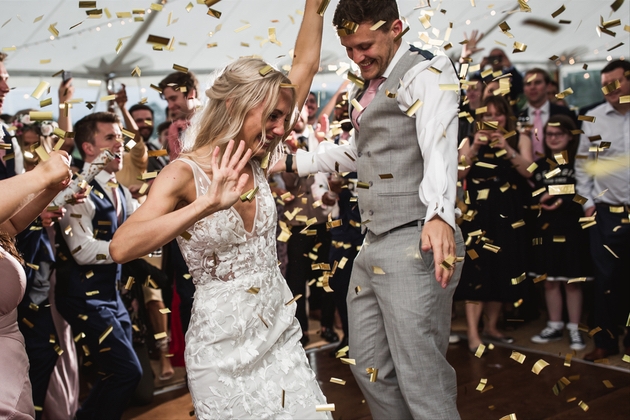 Newlywed couple dancing with confetti