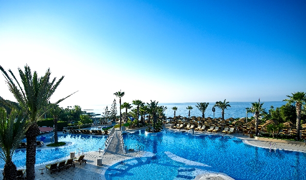 pool area with loungers blue sky sea in distance