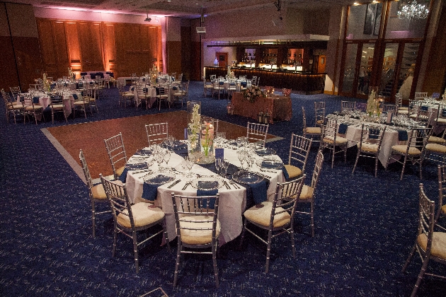 wedding breakfast tables set in in large room with blue carpet