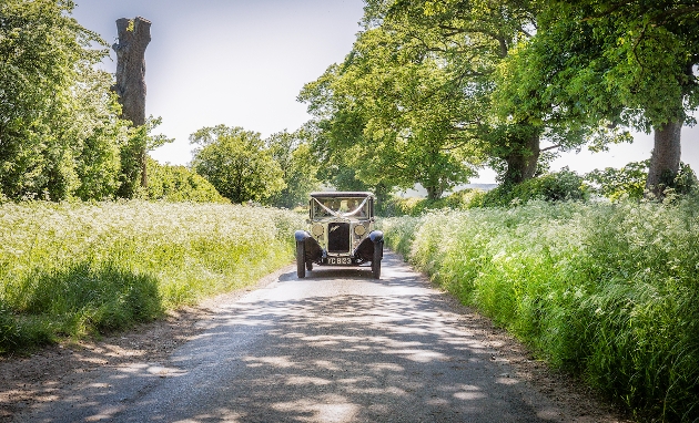 vintage car driving down country lane