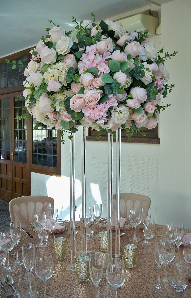 high centrepiece with blush floral display on sequin cloth