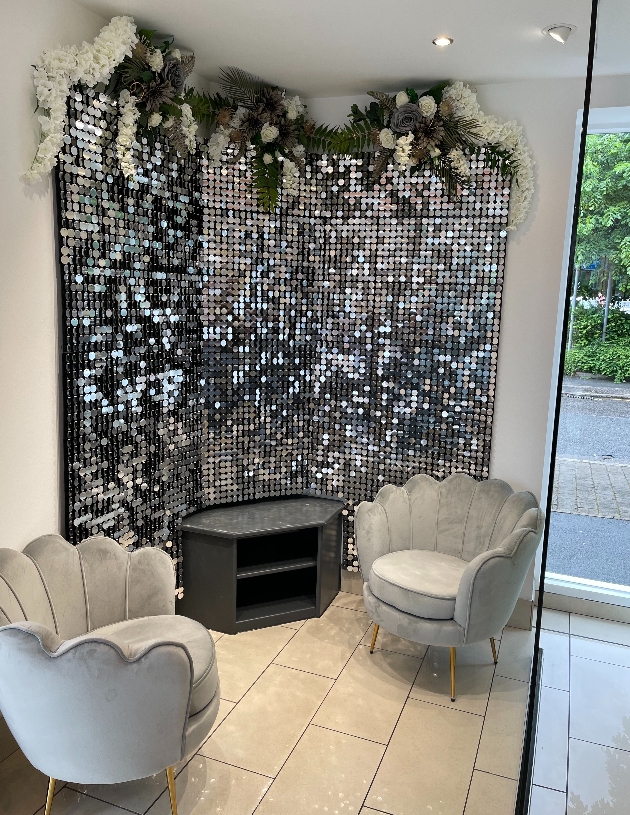 grey suede chairs in front of disco ball wall 