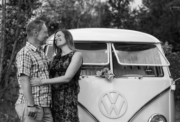 couple standing in front of retro campervan