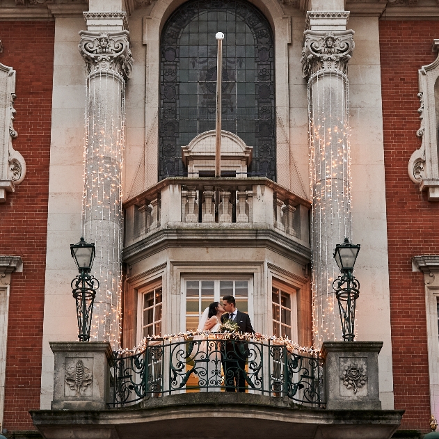 wedding couple on balcony of historic building 