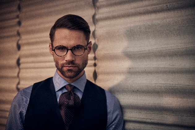 model in checked shirt and waistcoat and tie with glasses on