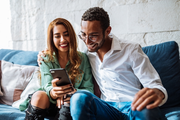 couple on sofa looking at their phone