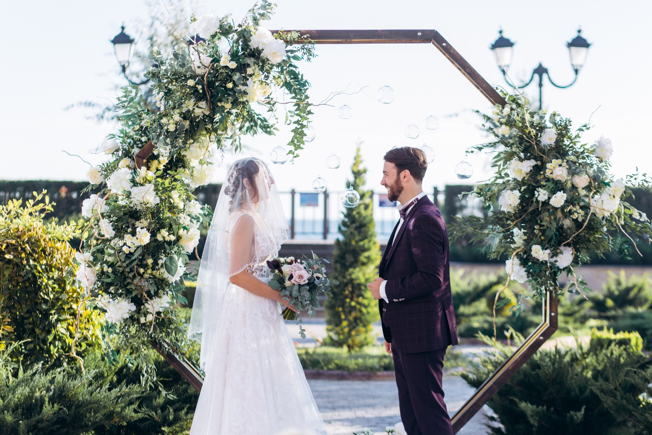 couple in front of a floral moongate on their wedding day