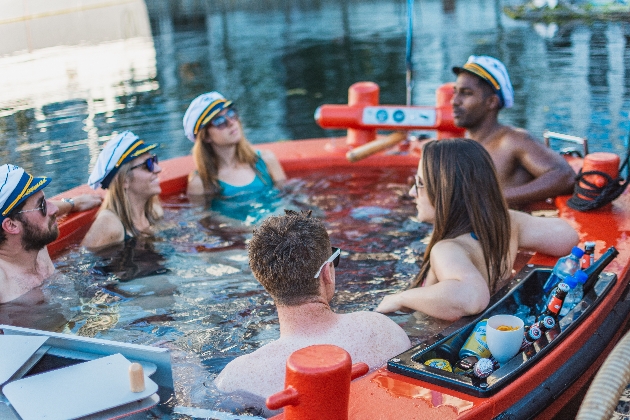 group of men and women in a floating hot tub down a river