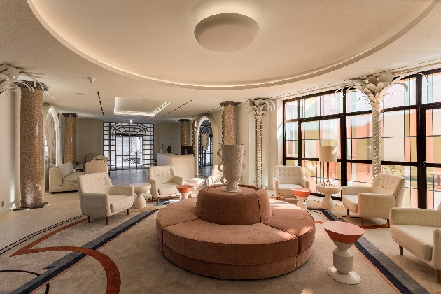 hotel lobby and reception room with cream and pink furniture and floor to ceiling window view