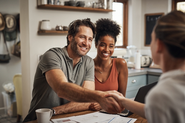 couple at a table shaking hands with a supplier