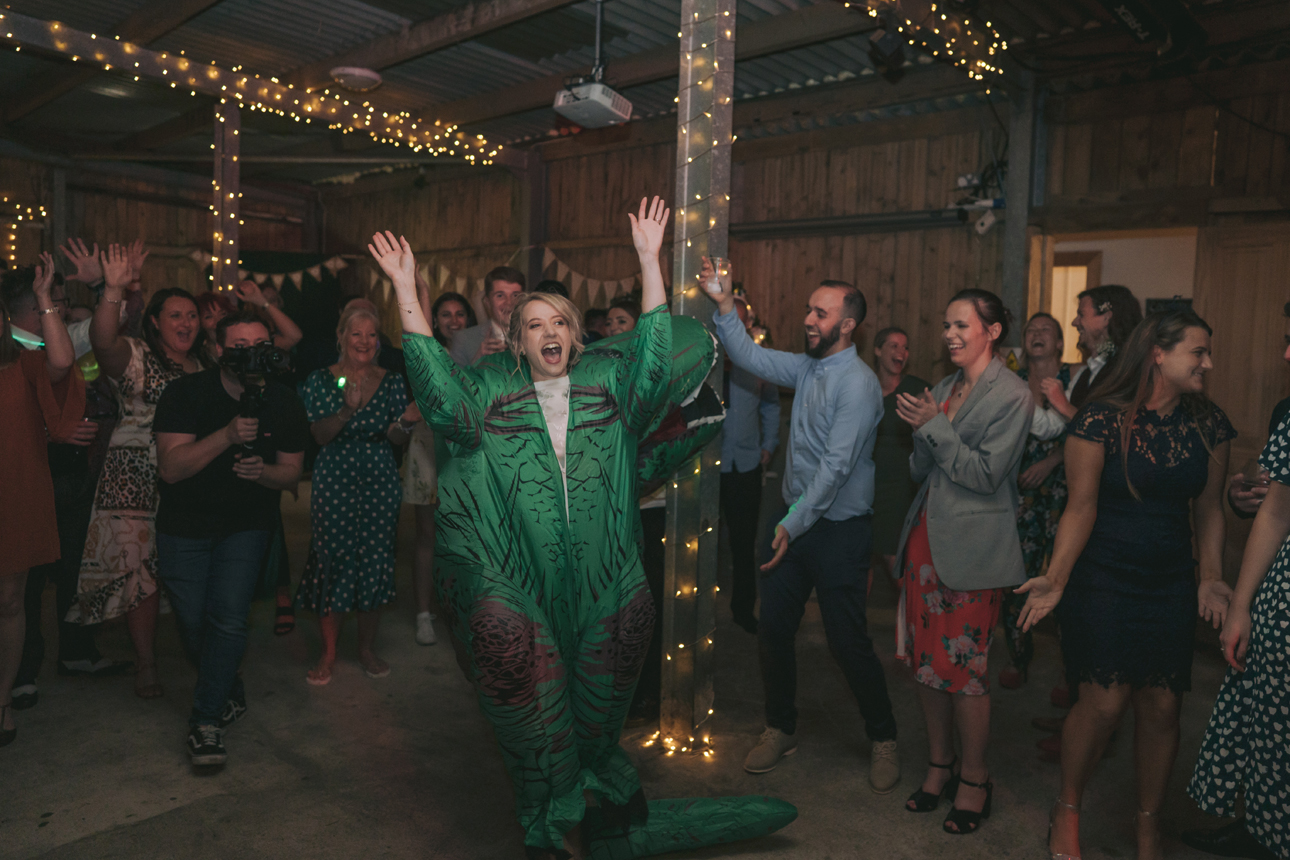Bride wears dinosaur costume on wedding dancefloor