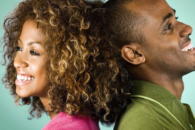 couple with the back of their heads leaning on each other in a pink and green top