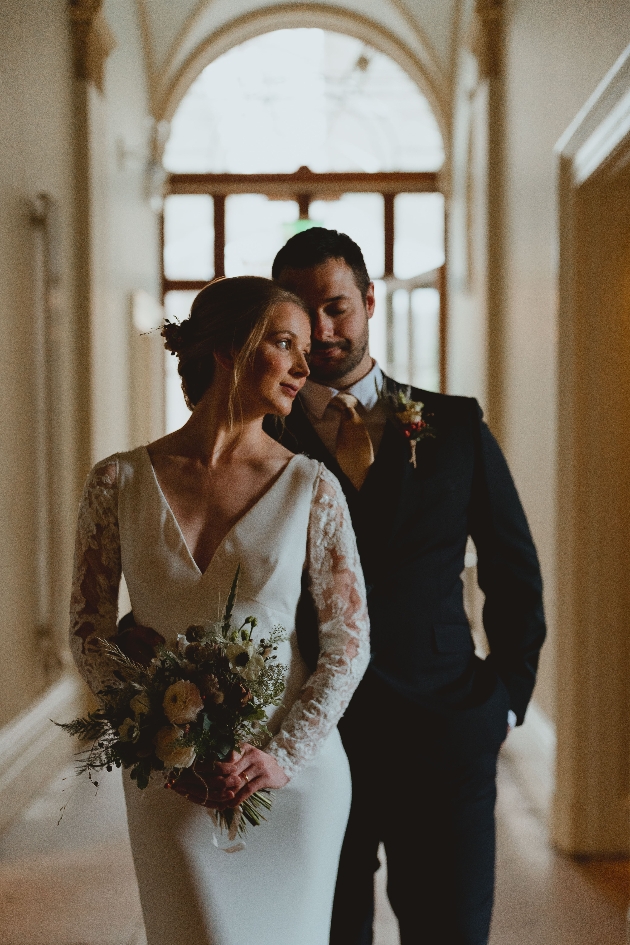 bride and groom standing in the hallway in a romantic pose