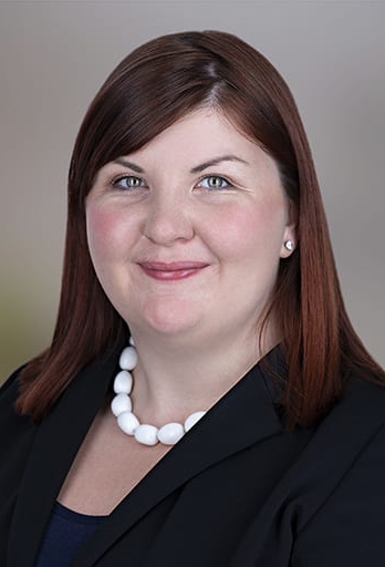 head shot of woman smiling in a suit jacket