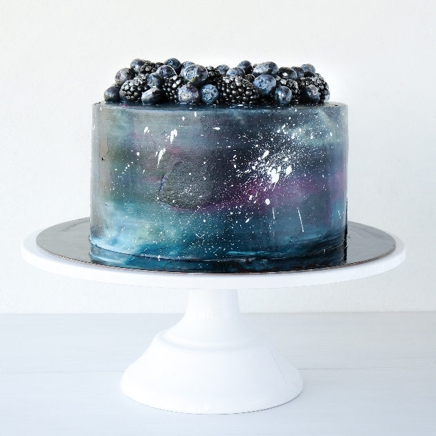 single tier cake with a space galaxy theme in blues and purples