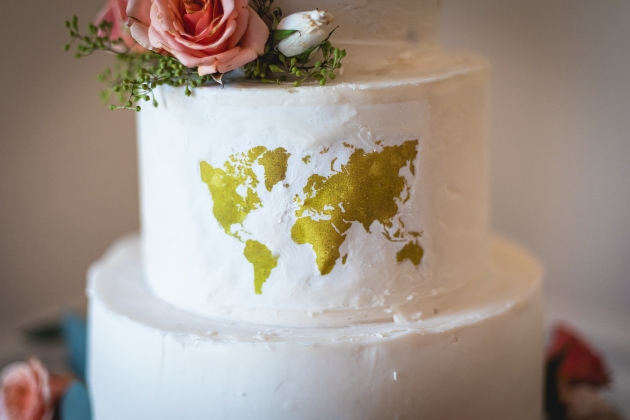 wedding cake tier with a gold map of the world on it 
