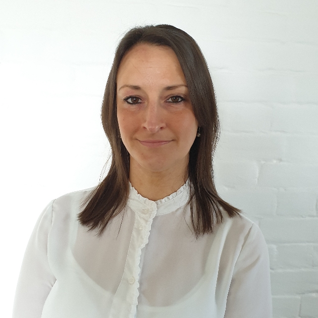 head shot of a lady with brown hair in a white blouse