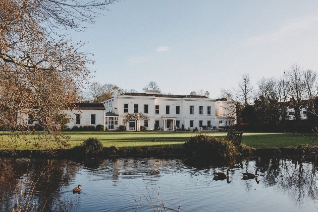 morden hall white manor house on the bank of a lake