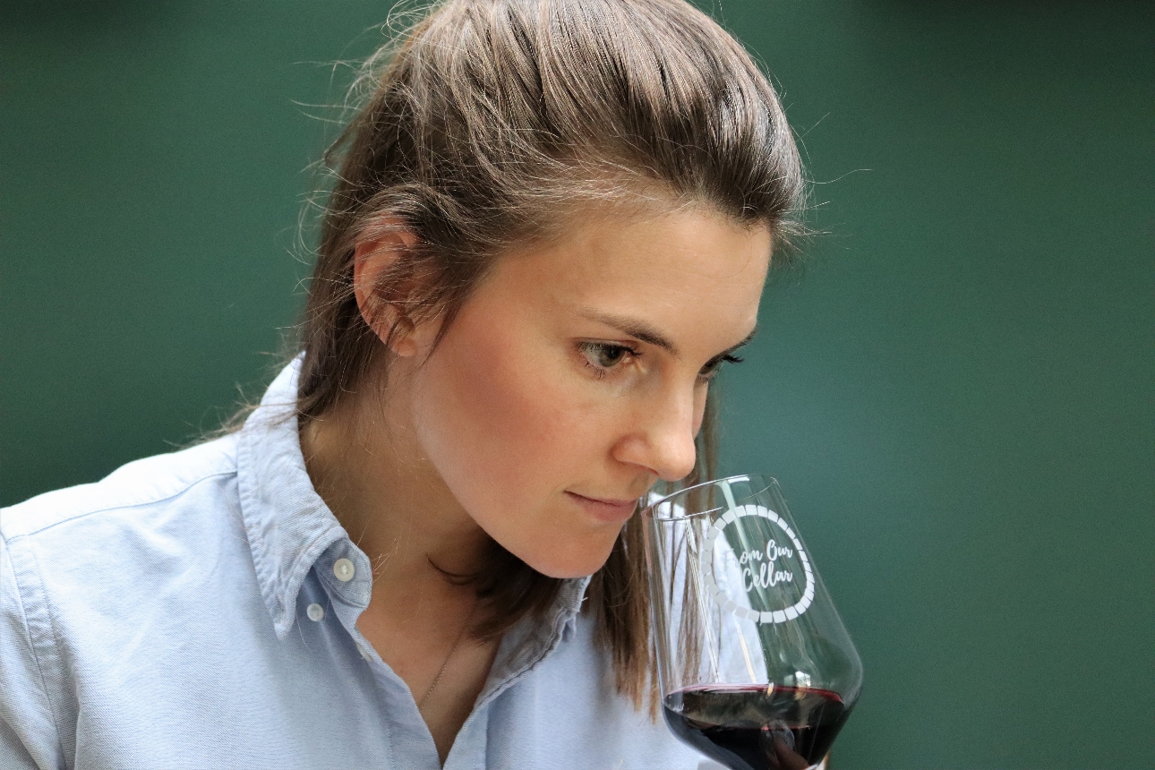 woman smelling red wine in a glass
