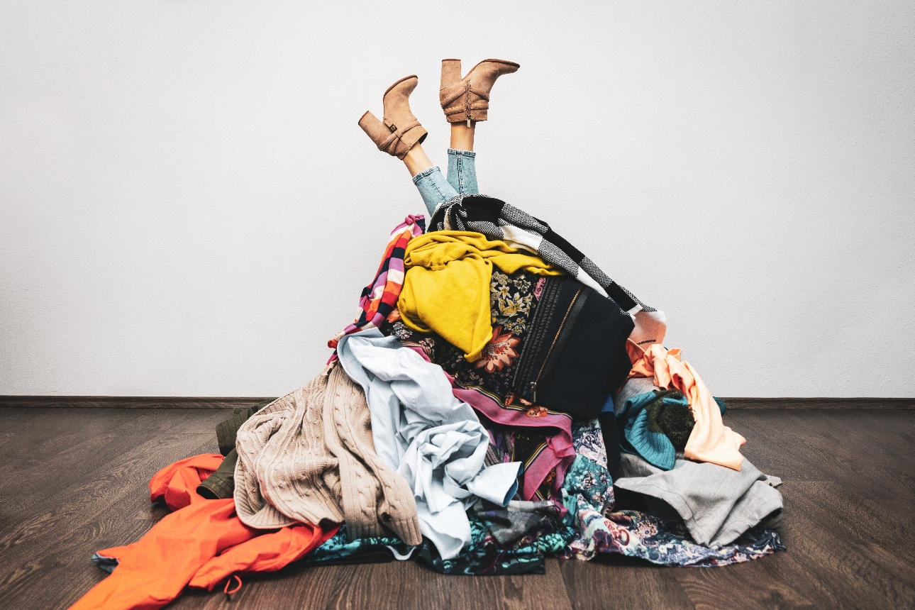 woman hidden under a pile of clothes