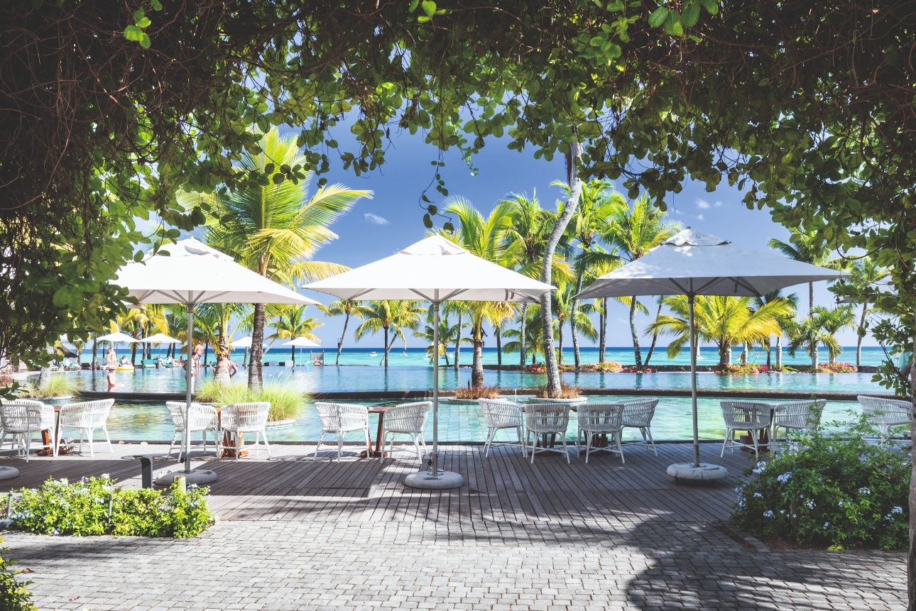 terraced with parasols, greenery, swimming pools, and sea