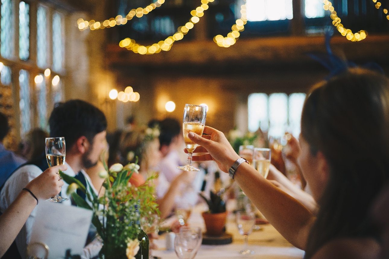 guests at a wedding raising their glasses for a toast