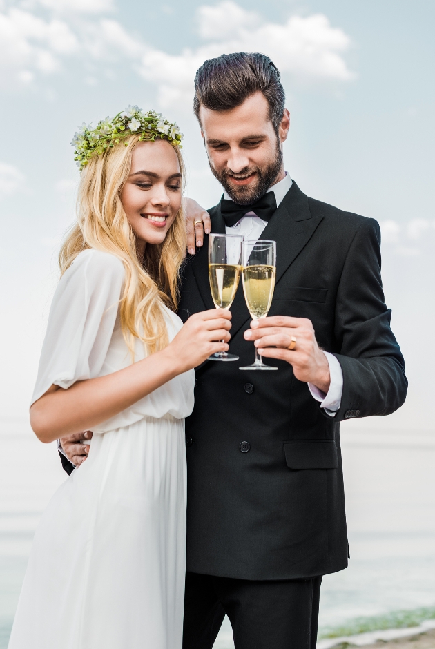 bride and groom embraced with a glass of champagne